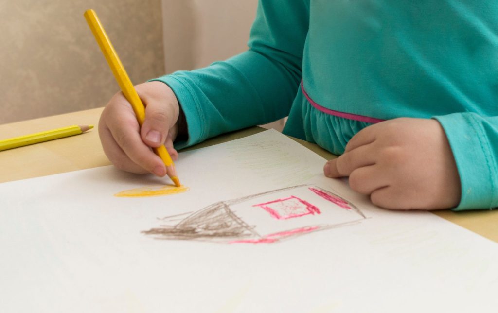 Enfant dessinant sur du papier dans le cadre d’une thérapie enfant à Montpellier